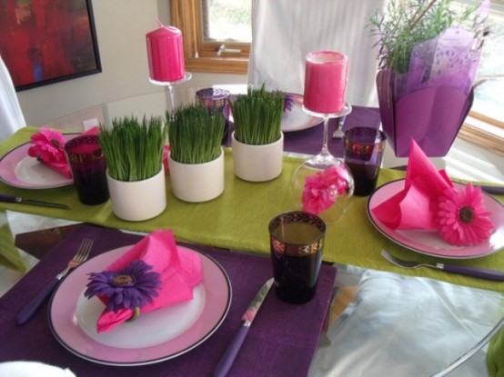 منظر طاولة ربيعي ملون مصنوع باللون الأرجواني والوردي والأخضر الفستقي بالإضافة إلى المساحات الخضراء في الأواني